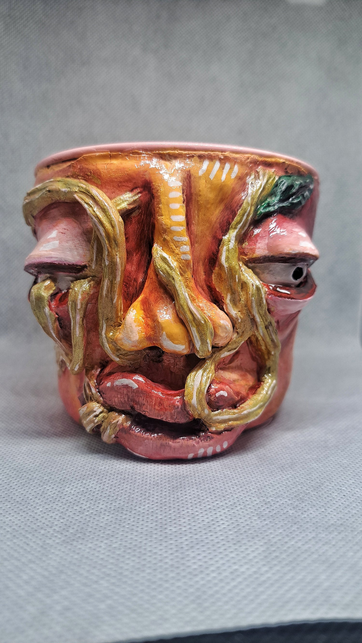 clay flowerpot with roots coming out of a face